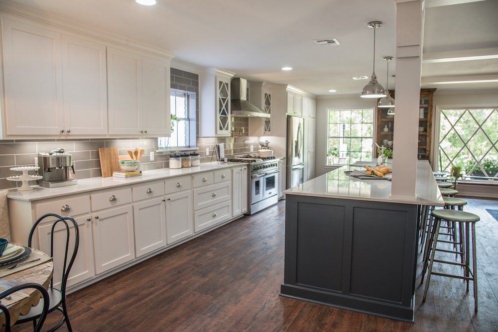 Kitchen with white shaker cabinets, a gray subway tile backsplash, a stainless range and a long dark gray island